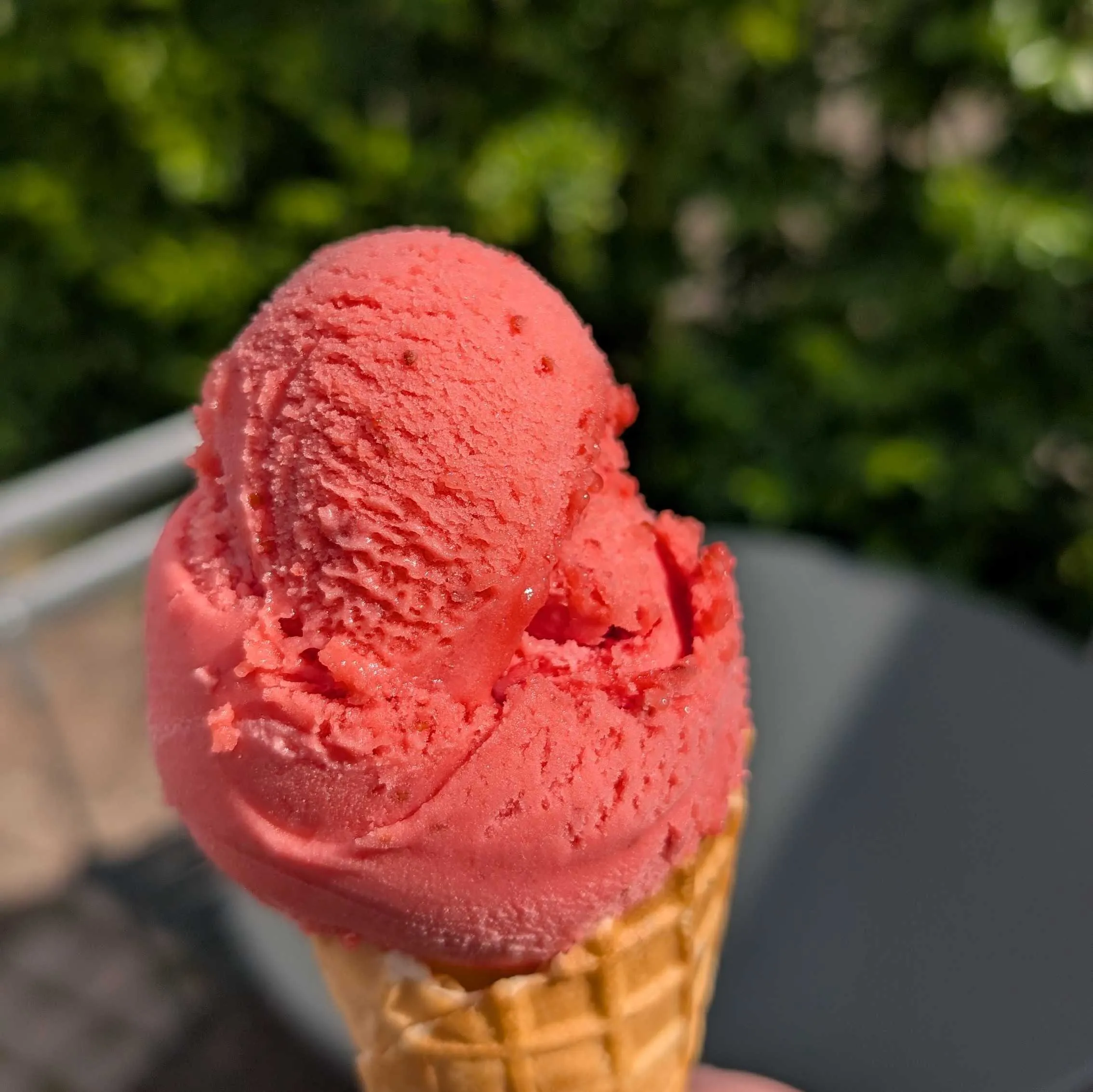 Lähikuva jäätelötötteröstä, jossa kirkkaan punaista sorbettijäätelöä.